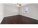A bedroom with dark wood floors, a ceiling fan, and a window providing natural light at 6259 Se 120Th Pl, Belleview, FL 34420