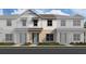 Charming two-story townhome with a light blue front door and beige accents on the facade at 6484 Barnstorm Way, St Cloud, FL 34771