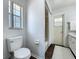 Bright bathroom features a toilet, window, and a shower with a white shower curtain at 670 Oleander St, Mount Dora, FL 32757