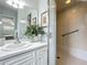 Bright bathroom with a glass-enclosed shower, modern vanity, and stylish decor at 670 Oleander St, Mount Dora, FL 32757