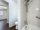 Bathroom with tiled shower/bath and safety bar, plus an open doorway to another room at 670 Oleander St, Mount Dora, FL 32757