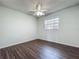 Bedroom with wood laminate flooring, window, and a ceiling fan at 670 Oleander St, Mount Dora, FL 32757