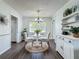 Cozy dining room showcases a charming chandelier, updated white furnishings, and wood-look floors at 670 Oleander St, Mount Dora, FL 32757
