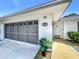 Close up on the front entrance of a charming home showing house number, garage and manicured bushes at 670 Oleander St, Mount Dora, FL 32757