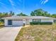Charming single-story home with a well-maintained lawn, attached garage and walkway to the front door at 670 Oleander St, Mount Dora, FL 32757