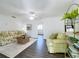 Bright living room with ceiling fan, stylish furnishings, and dark laminate flooring at 670 Oleander St, Mount Dora, FL 32757