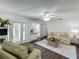 Cozy living room with glass doors to the lanai, updated flooring and a view to the kitchen at 670 Oleander St, Mount Dora, FL 32757
