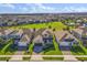 Aerial view of three homes, showing the neighborhood and well-manicured lawns at 674 Anna Ridge Rd, Minneola, FL 34715