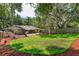 Lush, green backyard with mature trees, a patio, and a screened-in enclosure, perfect for outdoor living at 6750 Sunnyside Dr, Leesburg, FL 34748