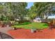 Beautiful backyard with mature trees, lush landscaping, and a well-maintained lawn, creating a private oasis at 6750 Sunnyside Dr, Leesburg, FL 34748