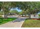 View of backyard, long driveway and storage shed on lush, well-maintained property, providing utility and curb appeal at 6750 Sunnyside Dr, Leesburg, FL 34748