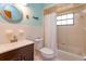 Cozy bathroom featuring white-tiled walls, a dark wood vanity and a shower and tub combination at 6750 Sunnyside Dr, Leesburg, FL 34748