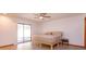 Bright bedroom featuring a sliding glass door, ceiling fan and a comfortable queen bed on a light wood frame at 6750 Sunnyside Dr, Leesburg, FL 34748