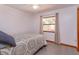 Bright bedroom with cozy rug, window, and a comfortable bed with a patterned quilt at 6750 Sunnyside Dr, Leesburg, FL 34748