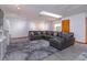 Spacious living room featuring a comfortable gray sectional couch and bright natural light from a skylight at 6750 Sunnyside Dr, Leesburg, FL 34748