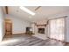 Cozy living room featuring a stone fireplace, skylight, and gray wood-look flooring at 6750 Sunnyside Dr, Leesburg, FL 34748