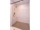 Modern shower featuring white subway tile and a decorative hexagon-shaped tile on the shower floor at 6750 Sunnyside Dr, Leesburg, FL 34748