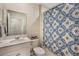 Cozy bathroom featuring a shower with a blue patterned shower curtain and a large mirror at 6816 Perch Hammock Loop, Groveland, FL 34736
