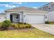 Charming home featuring a two-car garage, a landscaped front yard, and well-manicured lawn at 6816 Perch Hammock Loop, Groveland, FL 34736