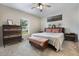 Comfortable primary bedroom featuring plush carpet, a ceiling fan, and natural light at 6816 Perch Hammock Loop, Groveland, FL 34736