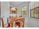 Charming dining area offers a wood table, seating for four, tile flooring and natural light from the windows at 684 Grand Canal Dr, Kissimmee, FL 34759
