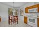 Inviting eat-in kitchen features tile flooring, oak cabinets, white appliances, and a view of the outdoors at 684 Grand Canal Dr, Kissimmee, FL 34759