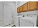 A functional laundry room with a washer, dryer, and overhead cabinets for storage at 684 Grand Canal Dr, Kissimmee, FL 34759