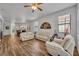 Bright living room featuring neutral walls, wood-look floors, fan and lots of natural light at 684 Grand Canal Dr, Kissimmee, FL 34759