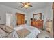 Relaxing main bedroom boasts a wooden dresser, a bed with accent pillows, and a ceiling fan for added comfort at 684 Grand Canal Dr, Kissimmee, FL 34759