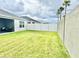 Spacious backyard with manicured lawn, patio, and a privacy fence at 7394 Lussier Ct, The Villages, FL 34762