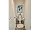 Cozy half bathroom with decorative palm tree art, modern toilet and wood-look flooring at 7394 Lussier Ct, The Villages, FL 34762
