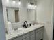 Bright bathroom featuring dual sinks, white cabinets, vanity and modern fixtures at 7394 Lussier Ct, The Villages, FL 34762