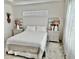 Comfortable bedroom featuring white walls, matching nightstands, decor, and soft lighting at 7394 Lussier Ct, The Villages, FL 34762