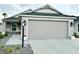 Charming home showcasing a clean two-car garage and well-maintained front yard with manicured rock landscaping at 7394 Lussier Ct, The Villages, FL 34762