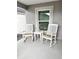Relaxing front porch furnished with two white rocking chairs and a small table, perfect for enjoying the outdoors at 7394 Lussier Ct, The Villages, FL 34762