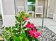 Close-up of the cozy front porch, with white rocking chairs and vibrant hibiscus flowers, creating a welcoming entrance at 7394 Lussier Ct, The Villages, FL 34762