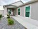 Inviting home entrance featuring a walkway, white trim windows, and rock landscaping with flowers at 7394 Lussier Ct, The Villages, FL 34762