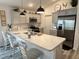 Spacious kitchen with stainless steel appliances, grey cabinets, long countertops, and a stylish breakfast bar at 7394 Lussier Ct, The Villages, FL 34762
