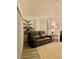 Well-lit living room featuring a comfortable leather sofa and a large plant next to the curtained window at 7394 Lussier Ct, The Villages, FL 34762