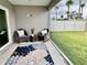 Screened in patio, with two chairs, a small table and a patterned rug at 7394 Lussier Ct, The Villages, FL 34762