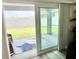 View of the patio, rug and backyard through sliding glass doors at 7394 Lussier Ct, The Villages, FL 34762