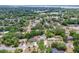 Expansive aerial view of a residential neighborhood with lush greenery and distant lake at 800 Jefferis Ct, Eustis, FL 32726