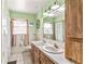 Bathroom with double vanity, large mirror, toilet, tiled shower, and wood-look details at 800 Jefferis Ct, Eustis, FL 32726