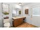 Bathroom with wood-look flooring, vanity, toilet, and door to the backyard at 800 Jefferis Ct, Eustis, FL 32726