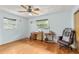 Light-filled room with hardwood floors, ceiling fan, two windows, and sewing setup at 800 Jefferis Ct, Eustis, FL 32726