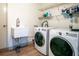 This laundry room has shelving, a wash basin, and a washing machine and dryer at 800 Jefferis Ct, Eustis, FL 32726
