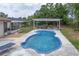 Inviting backyard featuring a kidney-shaped pool with a covered lounge area, perfect for outdoor relaxation at 800 Jefferis Ct, Eustis, FL 32726