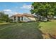 Green backyard featuring mature trees, lush lawn, and view of the home's rear exterior at 802 San Salvador Dr, The Villages, FL 32159