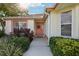Charming front entrance with a decorative wreath, colorful flower bed, and manicured shrubs at 802 San Salvador Dr, The Villages, FL 32159