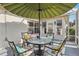Inviting screened patio with outdoor seating, a large umbrella, and a view of the surrounding landscape at 802 San Salvador Dr, The Villages, FL 32159